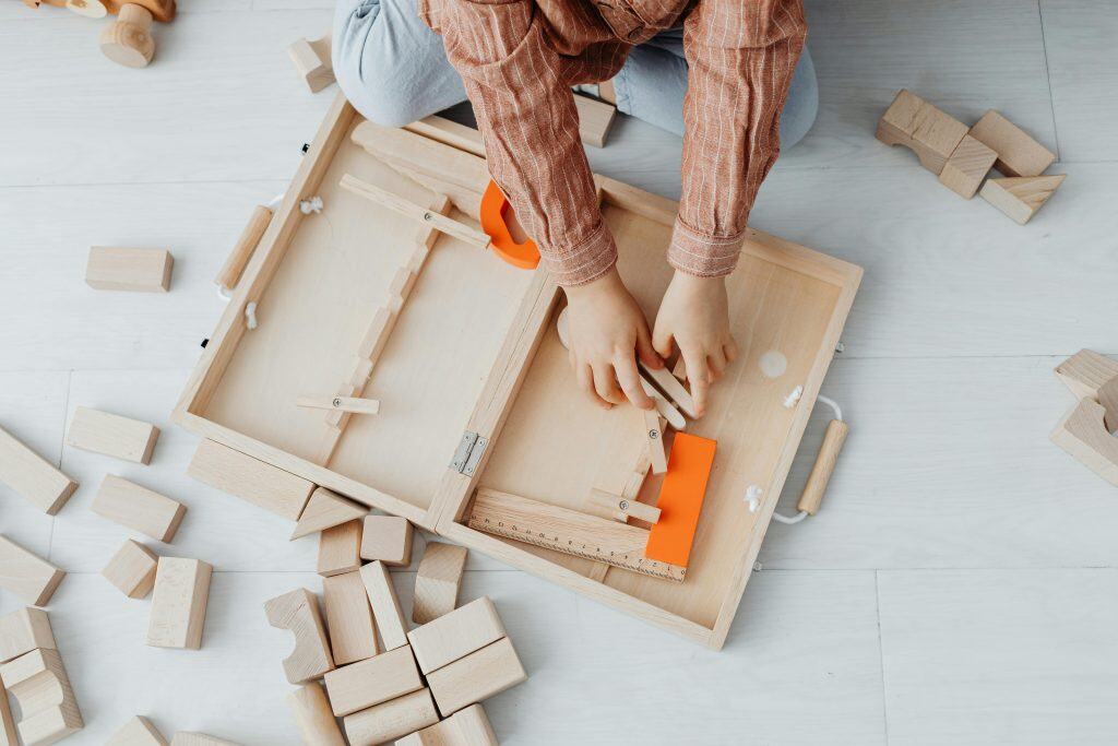Overhead Shot of a Kid's Arms Near Wooden Blocks