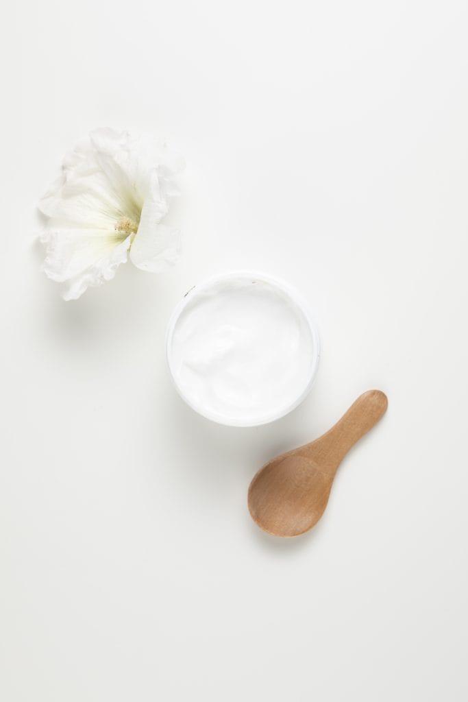 Top view of natural body butter and hibiscus flower