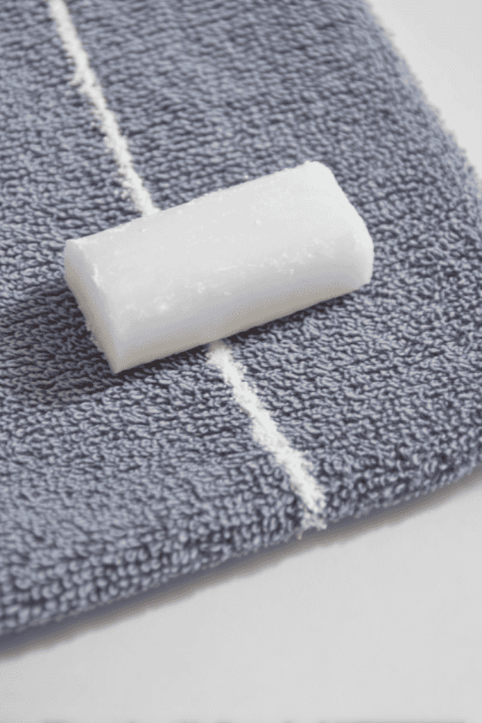 Close-up of soap sliver marking a straight line on fabric