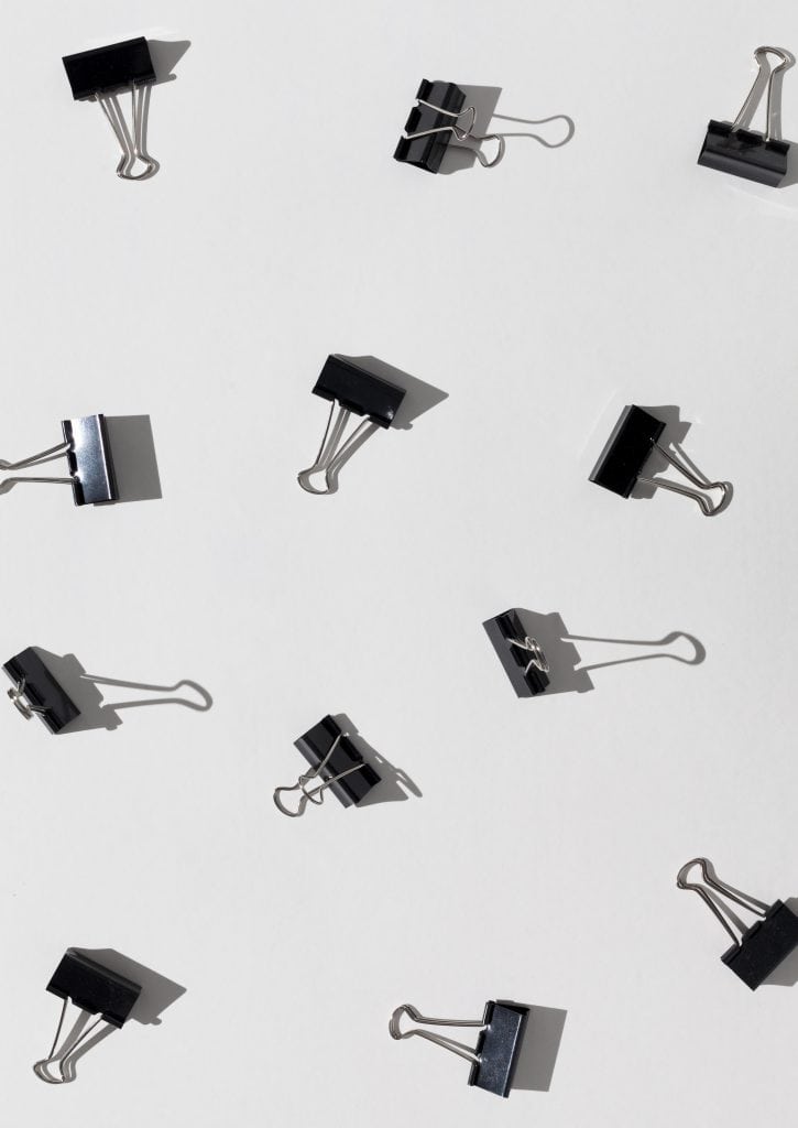 Flat lay paper clips on white background