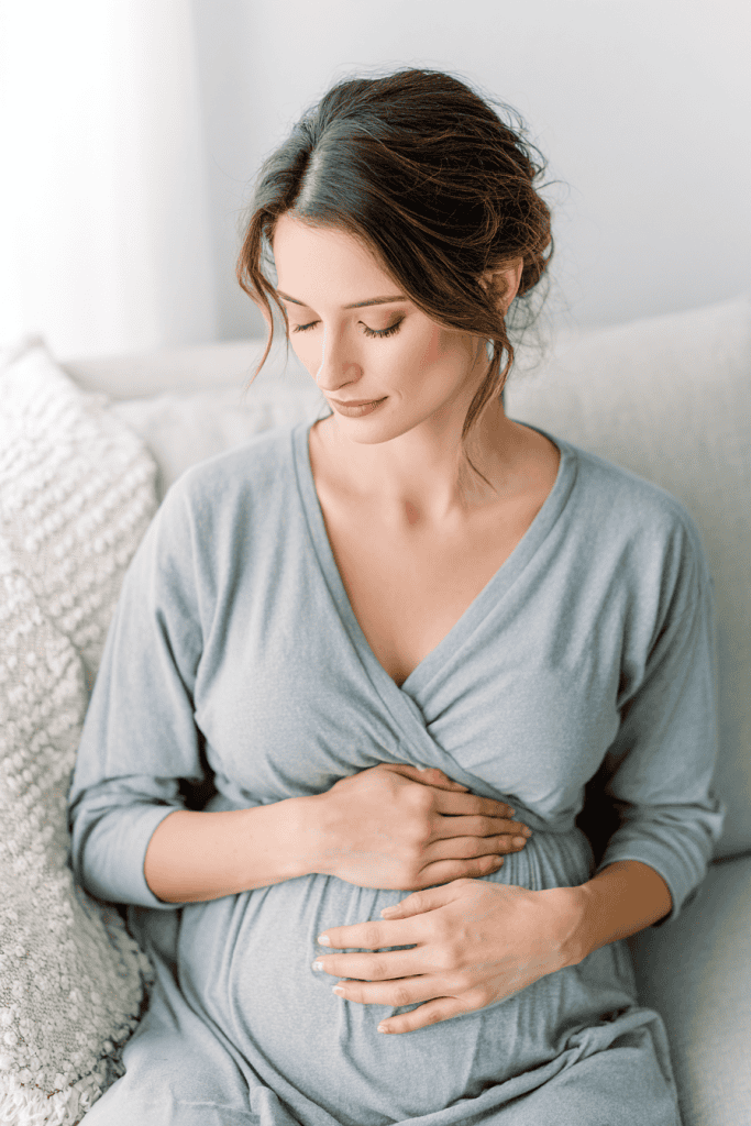 Pregnant mother sitting on sofa resting with eyes closed