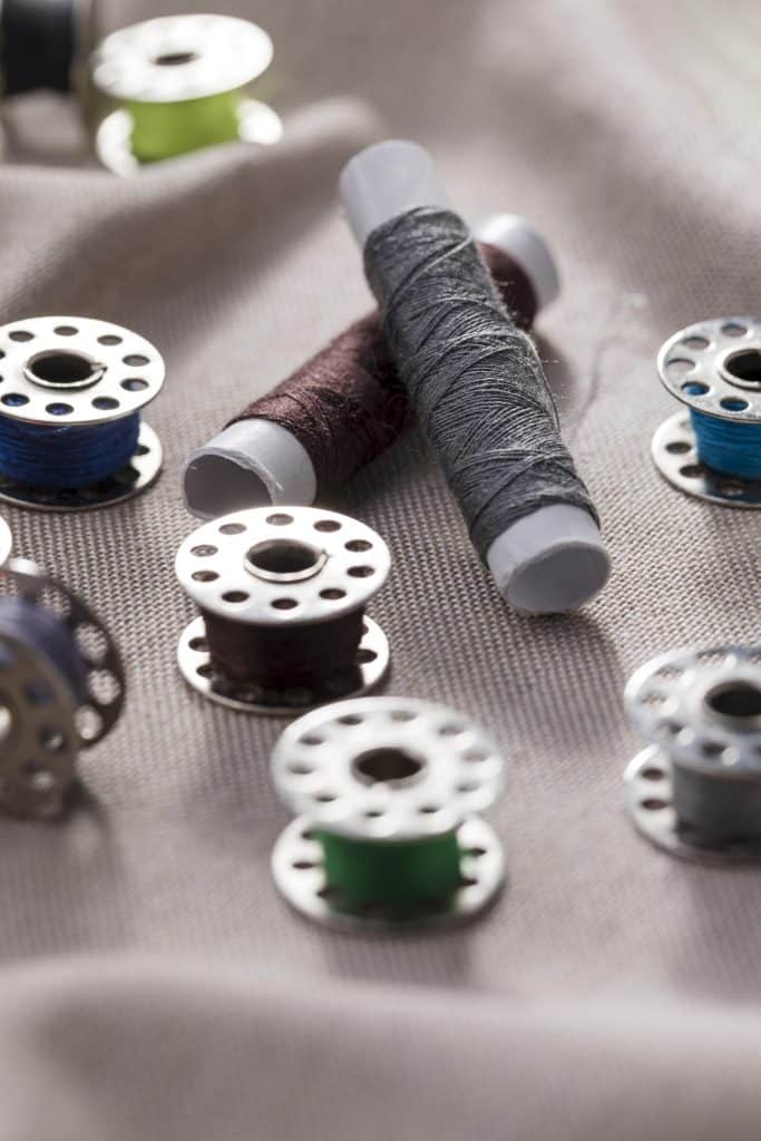 sewing machine bobbin case with fresh bobbin inserted