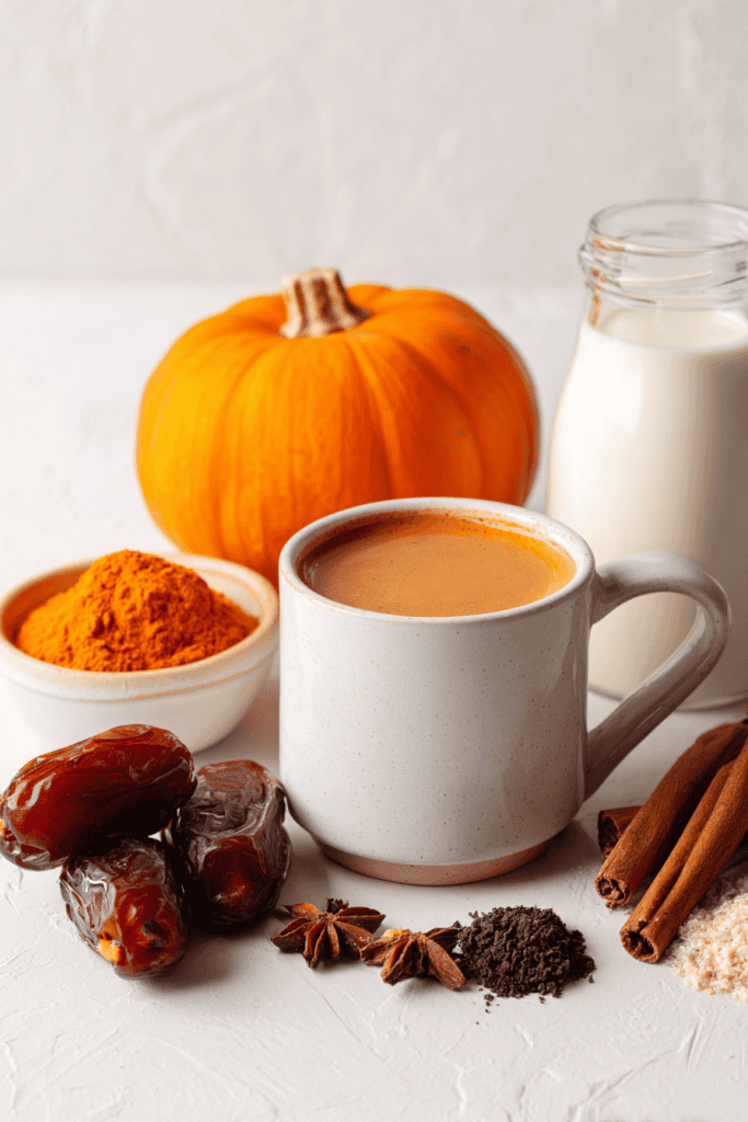 All ingredients for healthy pumpkin spice latte arranged neatly beside modern empty coffee mug