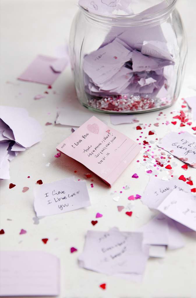 homemade Valentine’s "I Love You" coupons displayed in a soft, romantic flat-lay composition.