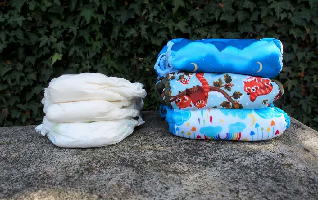 Two stacks of diapers placed on a stone surface outdoors.