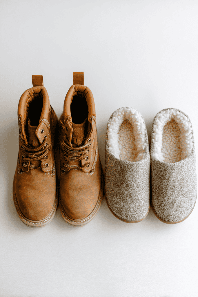 Toddler capsule wardrobe footwear, flat lay of sturdy brown boots and cozy indoor slippers