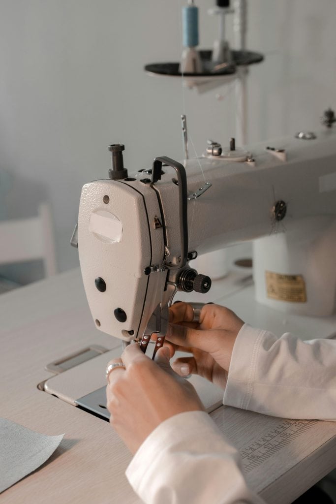 a person setting up a sewing machine before using