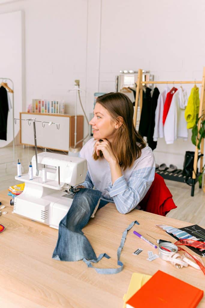 A woman using a white sewing machine