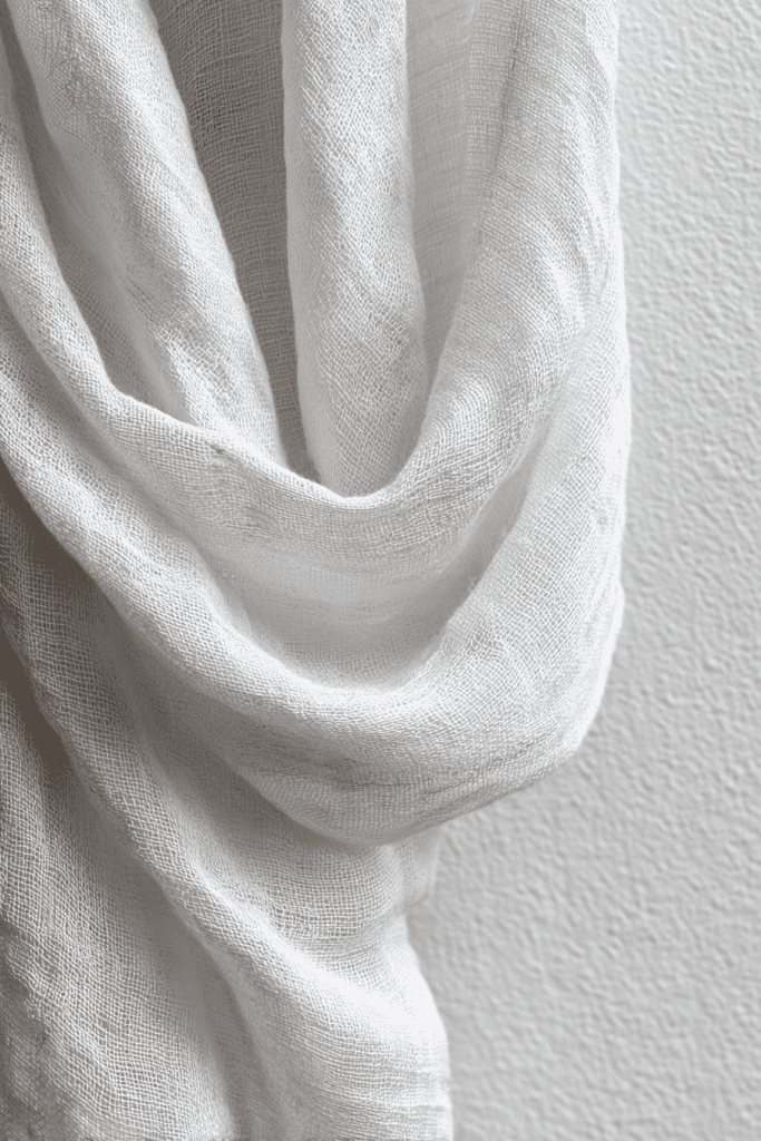 close-up of natural linen fabric gently draped with visible weave texture