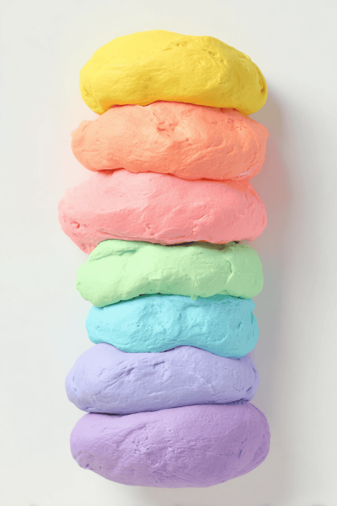 a neatly arranged stack of homemade cloud dough in vibrant pastel colors