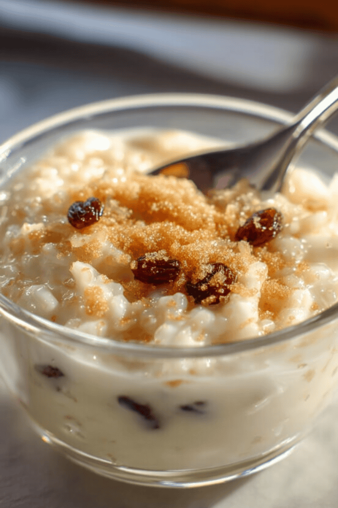 food photograph of creamy rice pudding made with almond milk, served in a small clear glass bowl