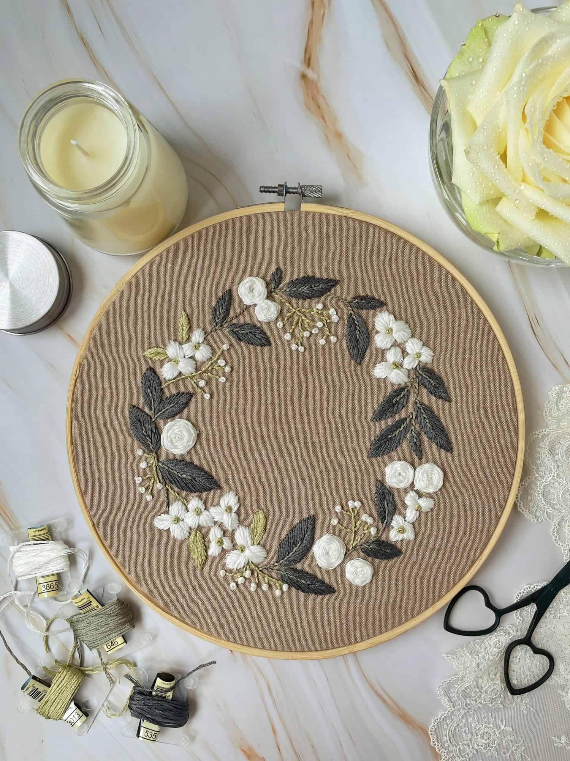 an elegant hand embroidery hoop featuring a delicate floral wreath design