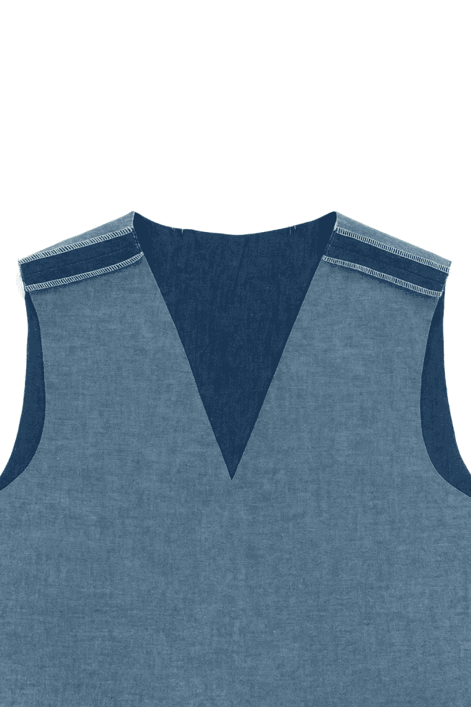close-up of a handmade garment in progress, V-neck bodice made of blue chambray fabric with finished serged shoulder seams
