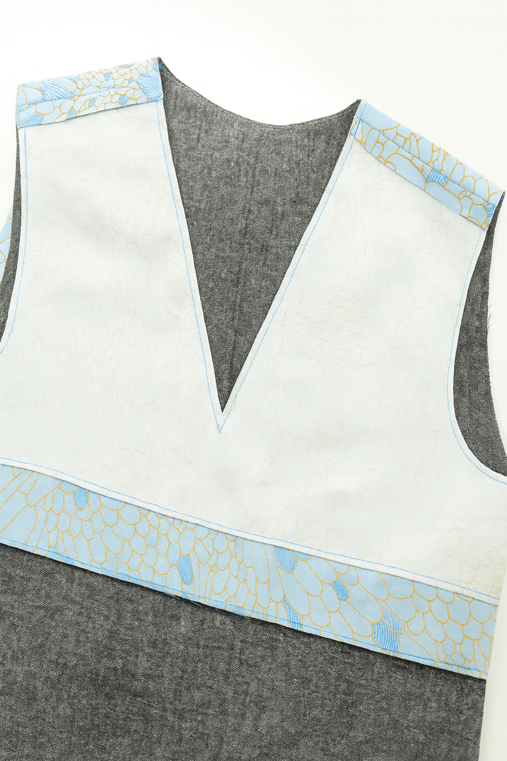 close-up of a handmade garment in progress, showing a V-neck bodice with lining partially sewn