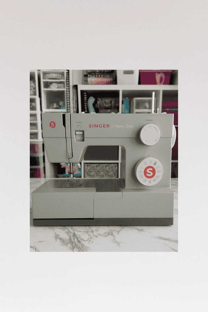 a SINGER Heavy Duty mechanical sewing machine positioned on a marble or light-patterned tabletop