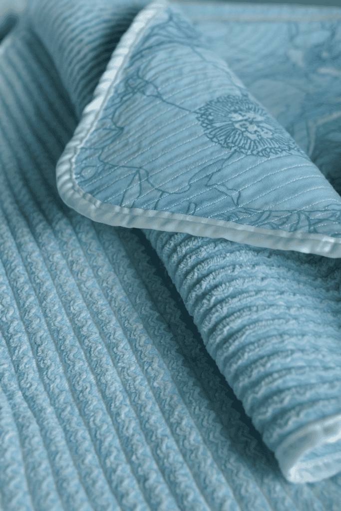 a beautifully crafted heirloom baby blanket, showcasing both the front and back textures