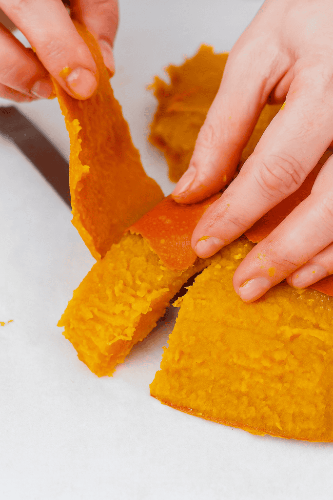 peeling the roasted skin off cooked pumpkin slices