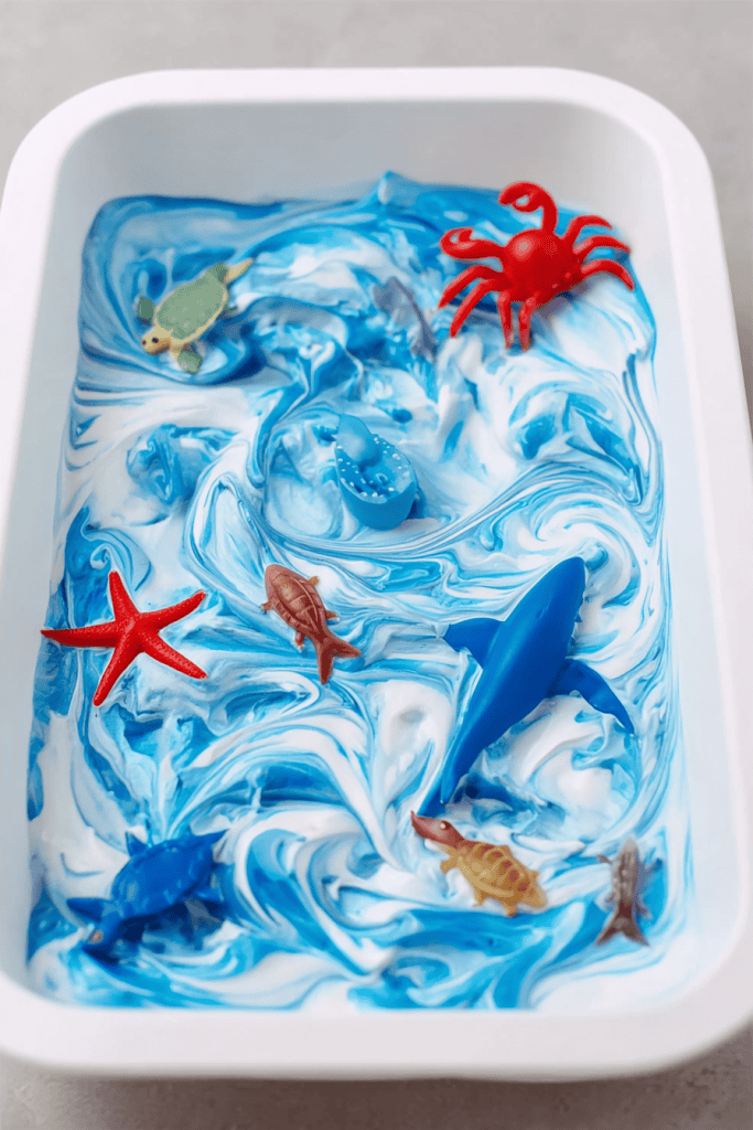 a sensory shaving cream tray with an ocean theme, designed for early childhood play