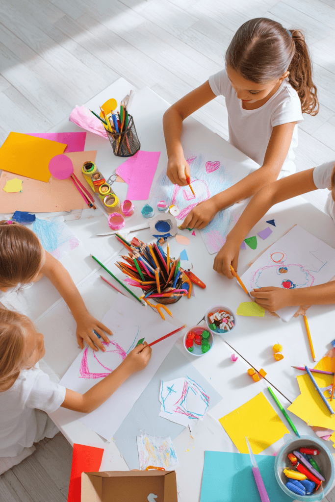 a Sunday School craft session in progress, featuring three young girls actively engaged in colorful paper-based crafts at a clean white table