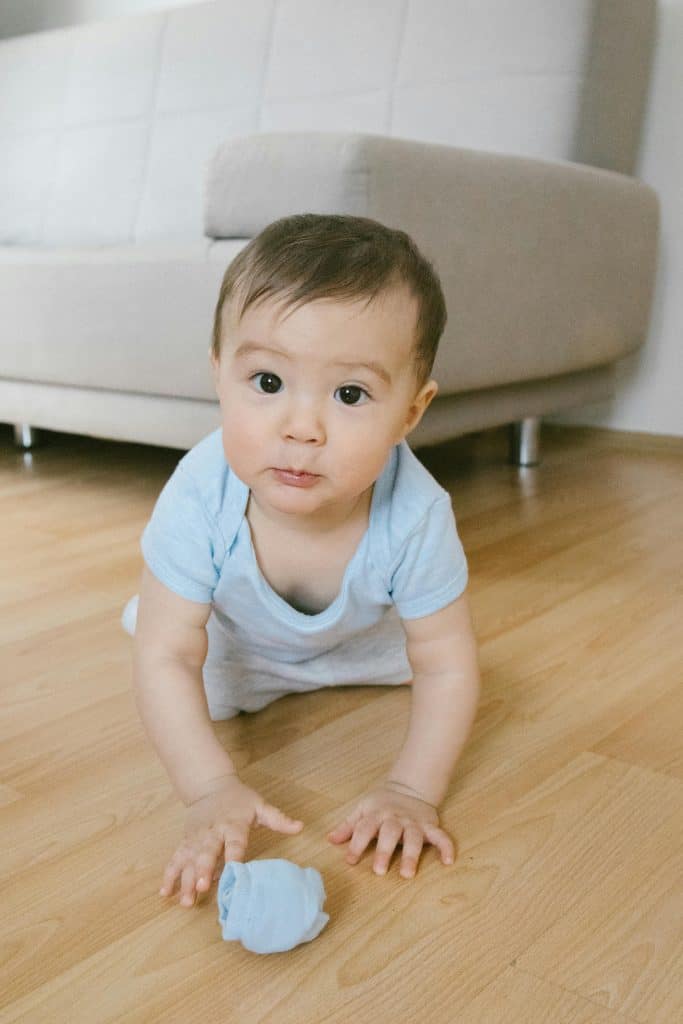 Toddler Crawling on a Wooden Floor