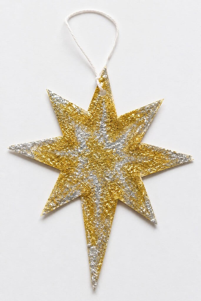 a handmade glittery eight-point paper star craft hanging from a string