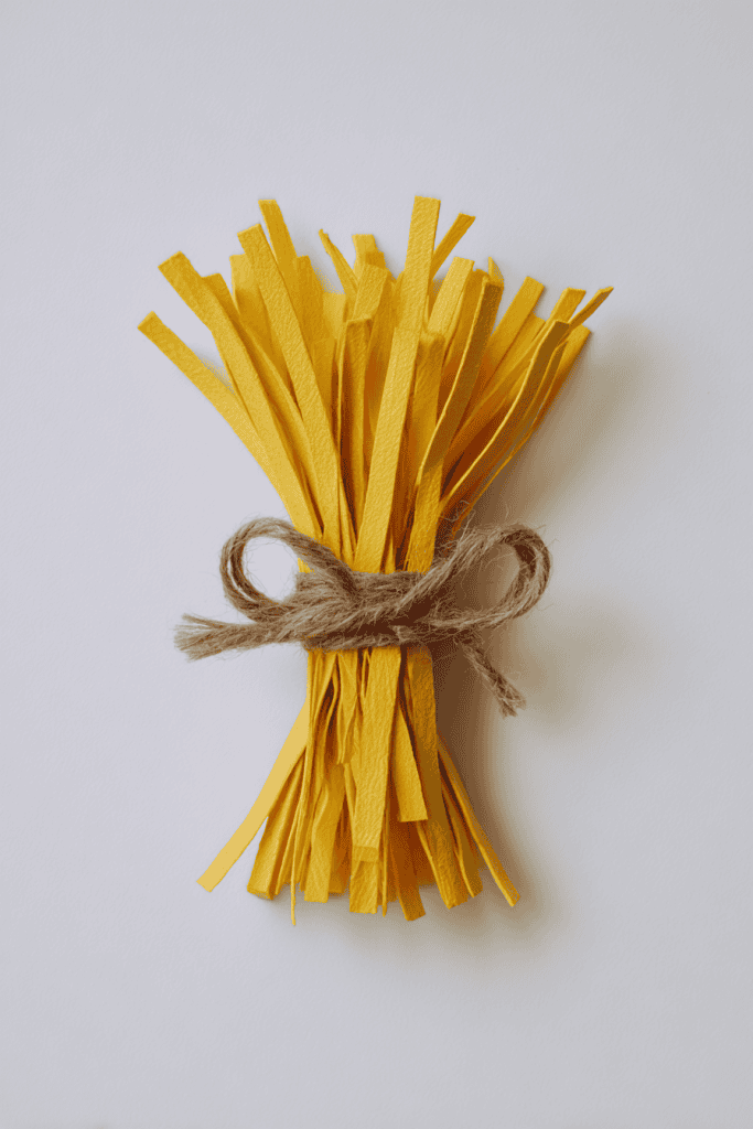 a bundle of "grain" made from yellow construction-paper strips, tied tightly with brown yarn
