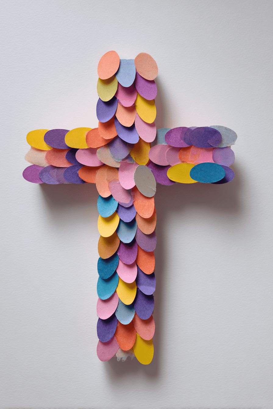 a simple toddler-made Sunday school craft: colorful paper mosaic cross with soft rounded pieces, cheerful pastel colors