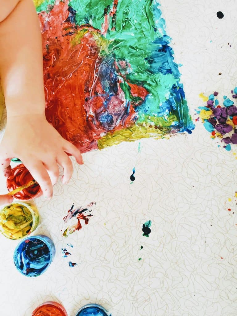 a kid's hand holding a paint