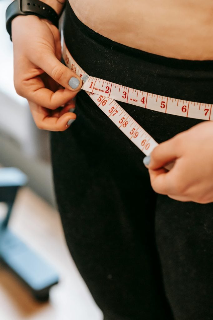 Woman measuring her hips
