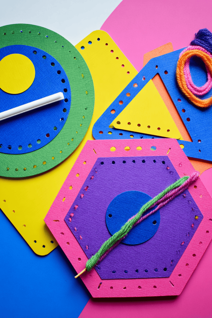  a vibrant Montessori-inspired lacing activity for children. The image features a set of colorful geometric lacing cards made from thick, matte-finish cardboard