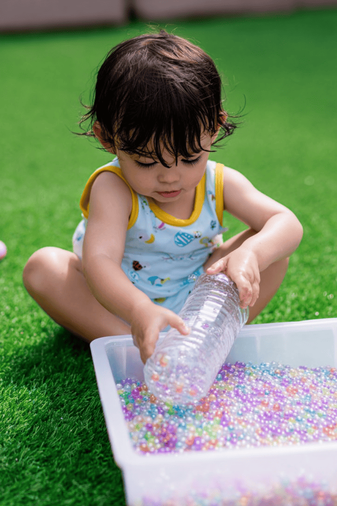 a toddler engaging in a sensory play activity outdoors