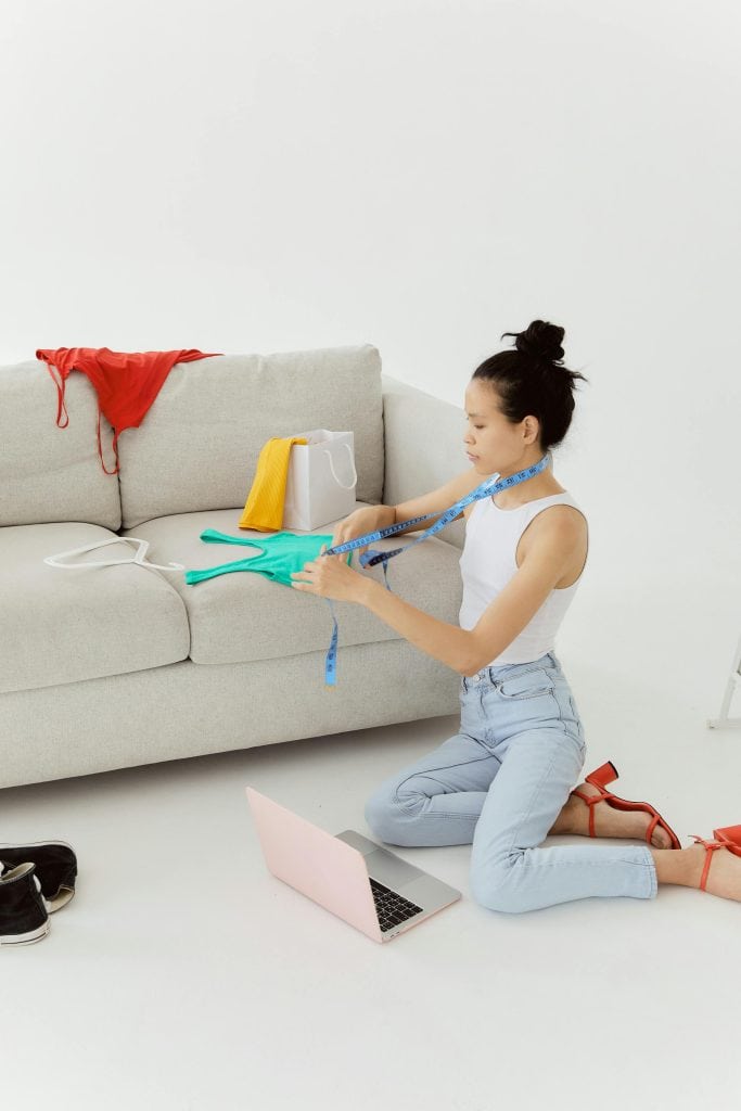 Woman in White Tank Top and Denim Jeans Sitting on the Floor