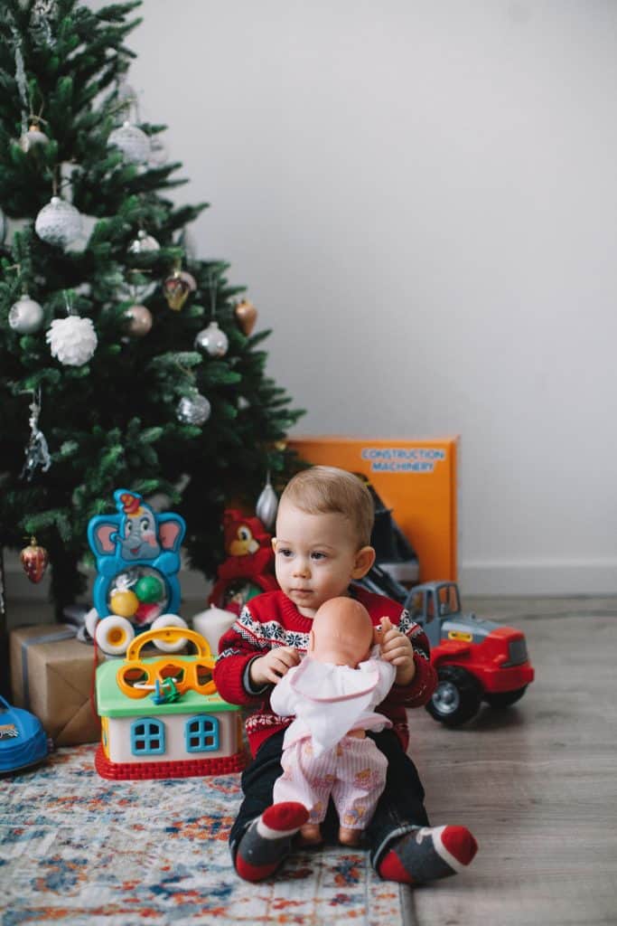 A Young Boy Sitting on Floor Beside Christmas Tree