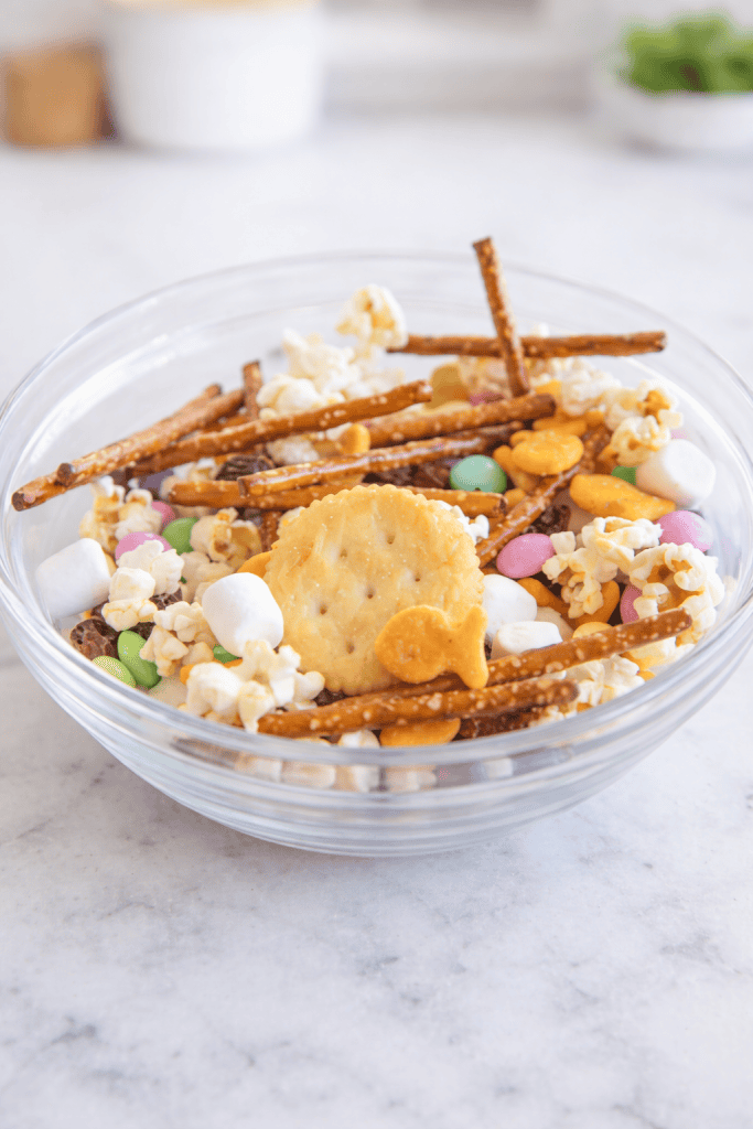 a colorful and playful snack mix served in a clear glass bowl.