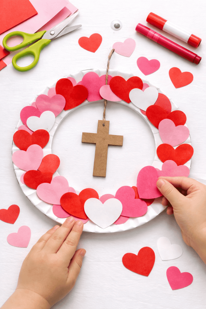 a handmade children’s Valentine’s Bible craft: a Heart and Cross Paper Plate Wreath.