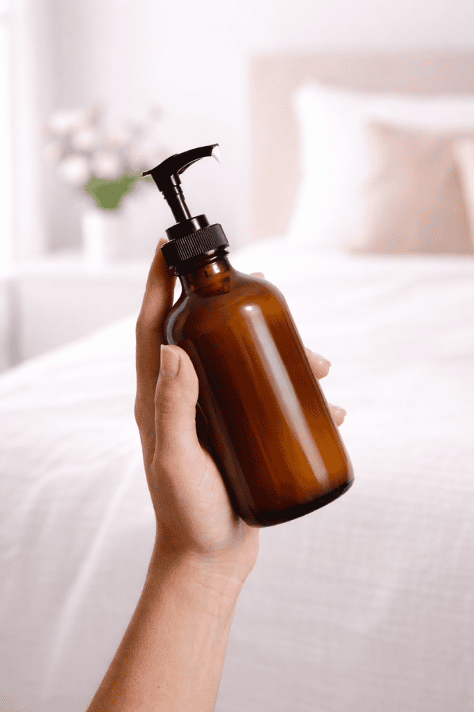 a person holding a dark amber glass pump bottle, perfect for natural skincare products like tallow lotion.