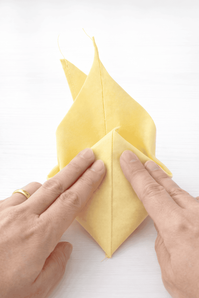 Pressing the fabric folds carefully