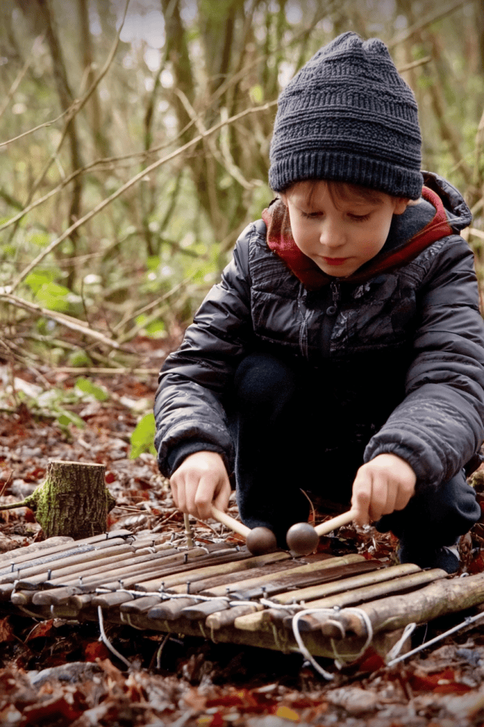 a young child playing a handmade wooden xylophone in a forest setting.