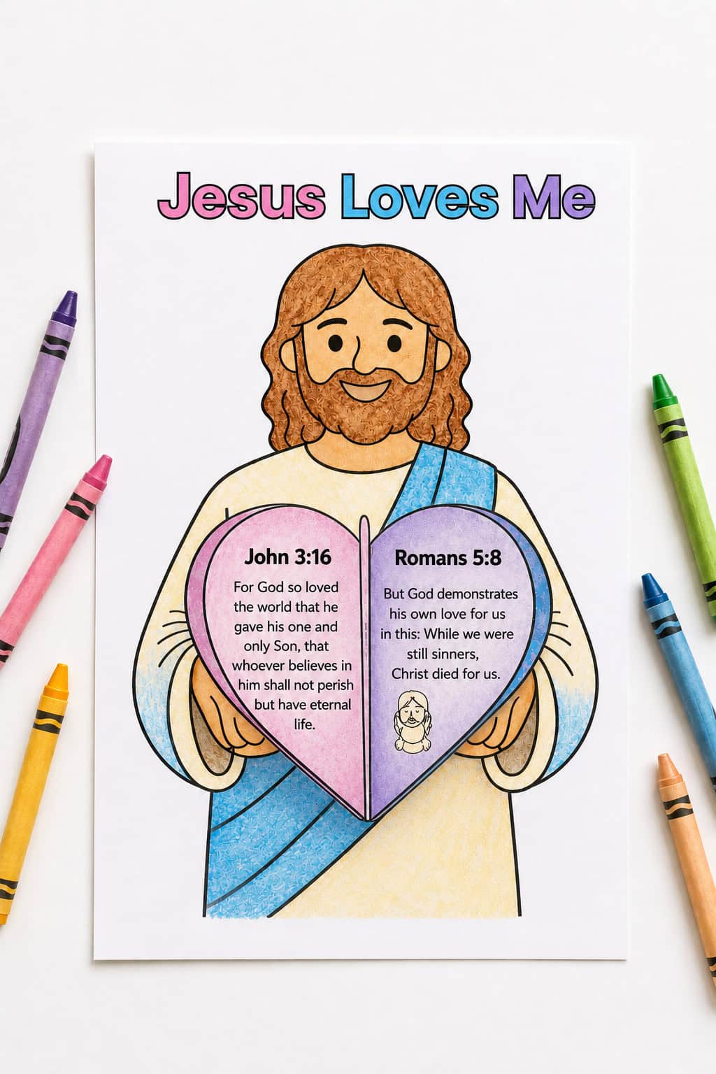 Colorful “Jesus Loves Me” coloring page on a bright white table, featuring Jesus holding a heart-shaped book with Bible verses, surrounded by crayons.