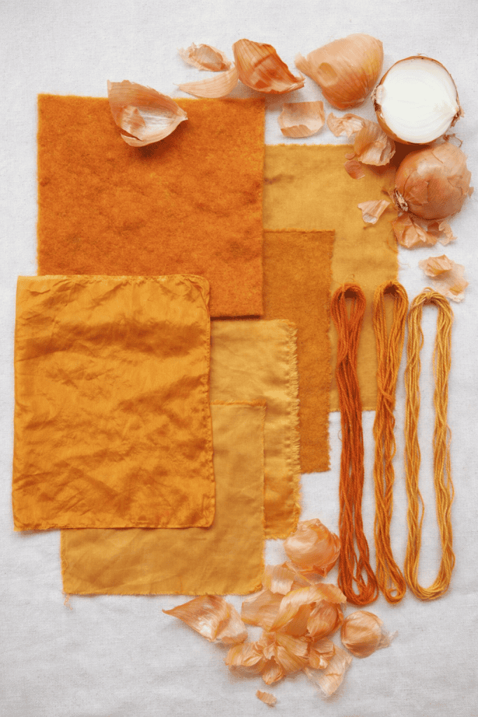 onion skin–dyed fabrics and threads on a bright, crisp white fabric tabletop background