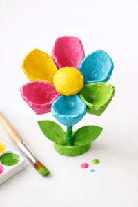 a colorful spring craft made from an egg carton, designed as a blooming flower.