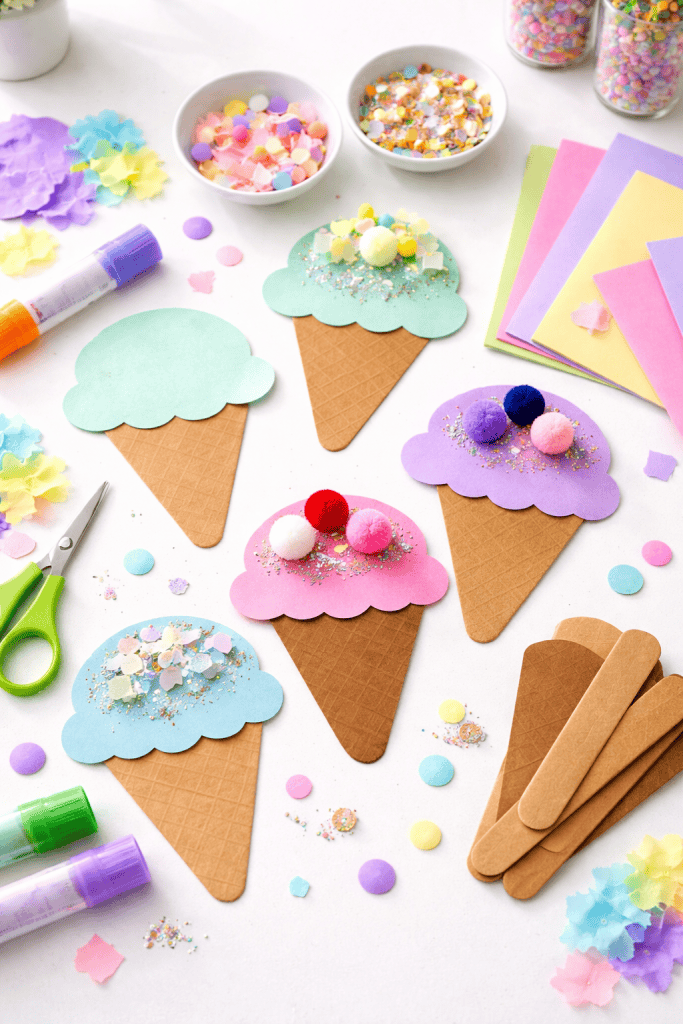 a paper cone ice cream craft for kids, arranged on a clean white table in a bright crafting space
