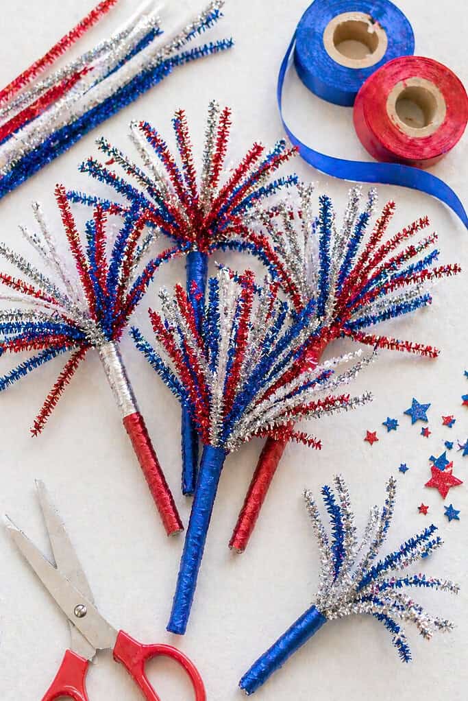 A small bundle of handmade “sparkler” crafts made from metallic pipe cleaners in red, blue, silver, and white.