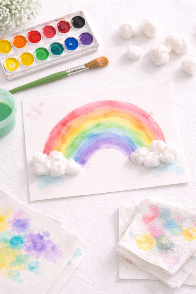 a piece of thick watercolor paper with a hand-painted rainbow made of broad, sweeping arches.