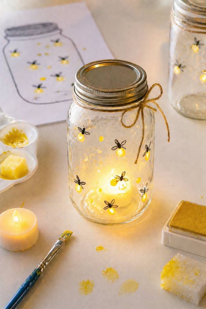 A clear mason jar (or paper version styled realistically) with soft glowing yellow “fireflies” painted or stamped around it