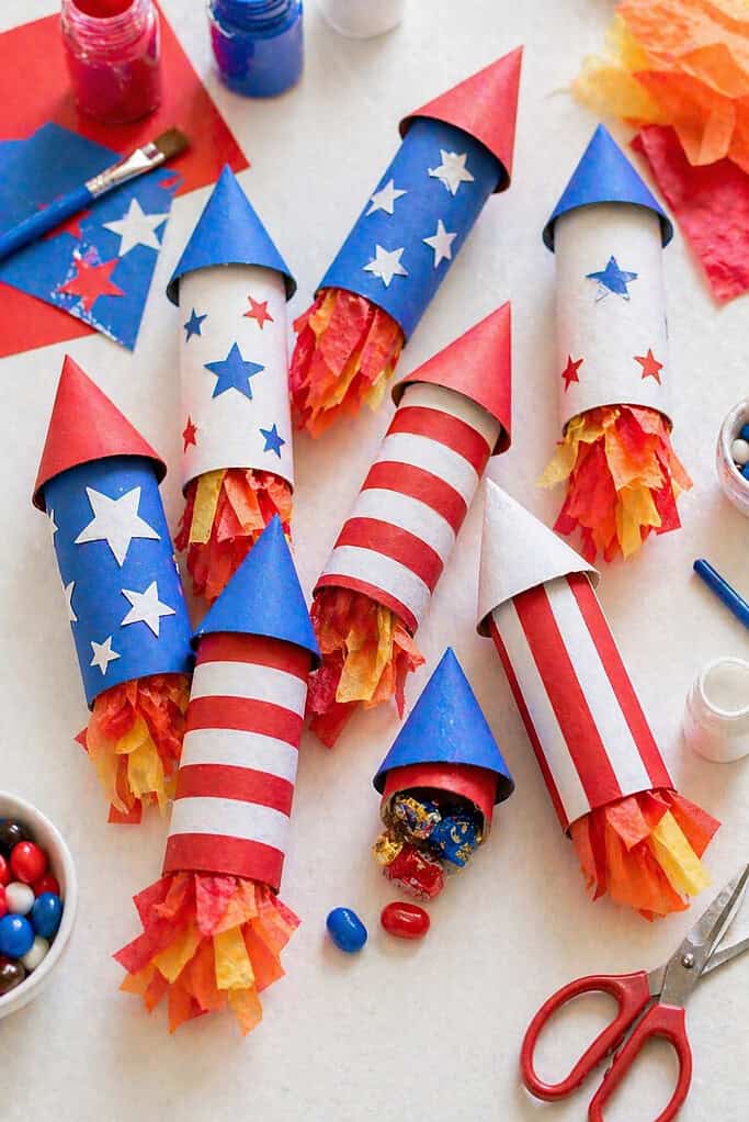A cluster of handmade rocket-shaped party favors crafted from toilet paper rolls and cardstock cone tops