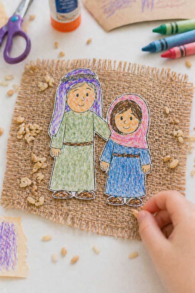 two simple human figures drawn and cut from white cardstock—one slightly taller or styled to represent Naomi (older), and one smaller to represent Ruth (younger)