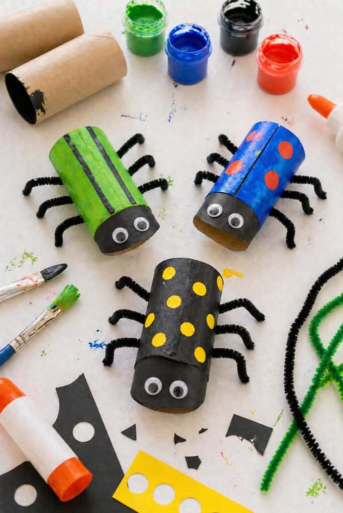 A toilet paper roll painted in rich, vibrant colors—deep black, shiny blue, or bright green—with visible brushstroke texture