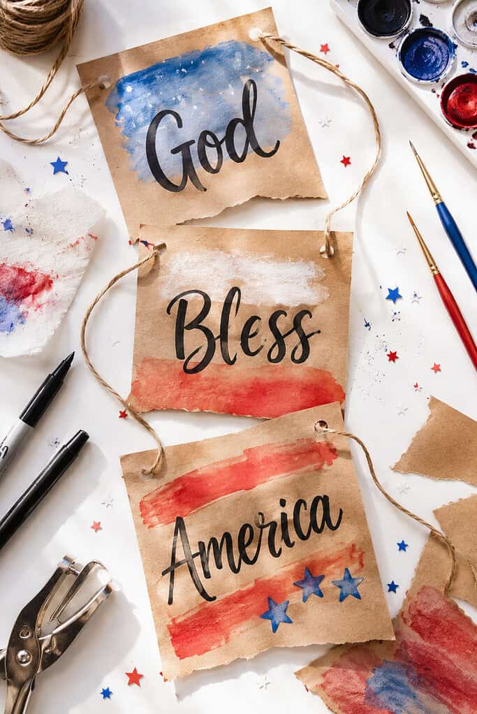 multiple brown kraft paper banner rectangles painted with red, white, and blue watercolor washes