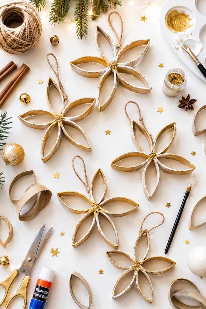 beautiful handmade five-pointed stars created from sliced and flattened toilet paper roll petals, arranged into delicate snowflake-like Christmas ornaments.